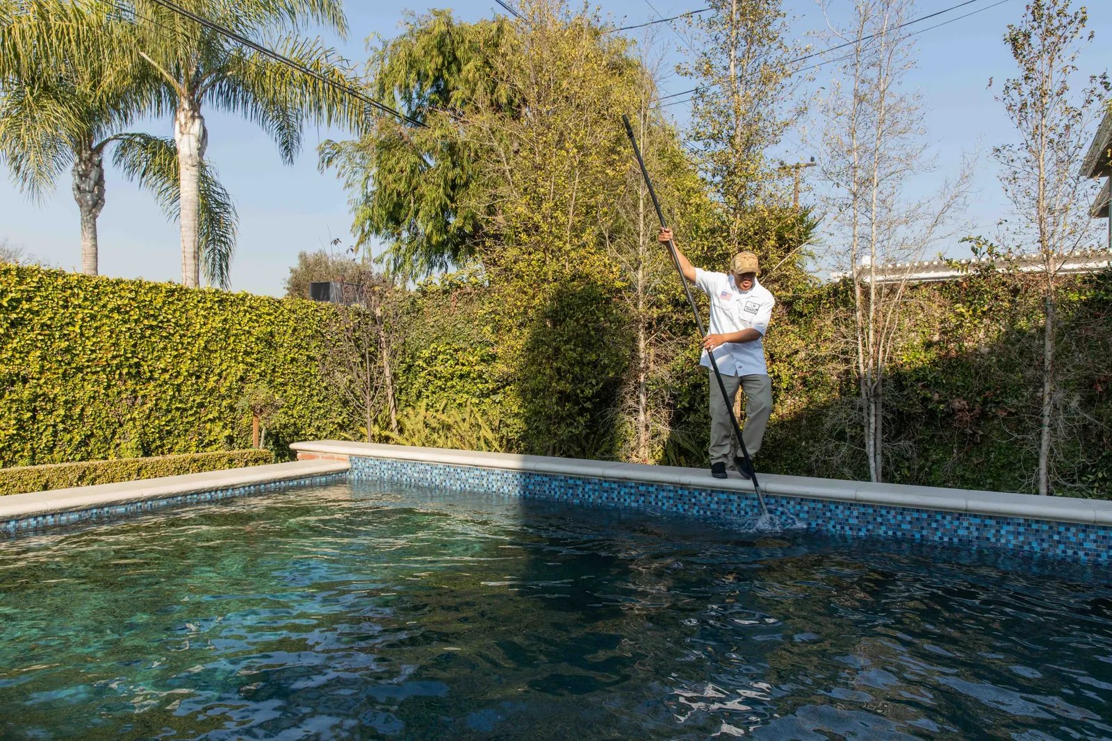 A clean residential backyard pool with clear, well-circulated water