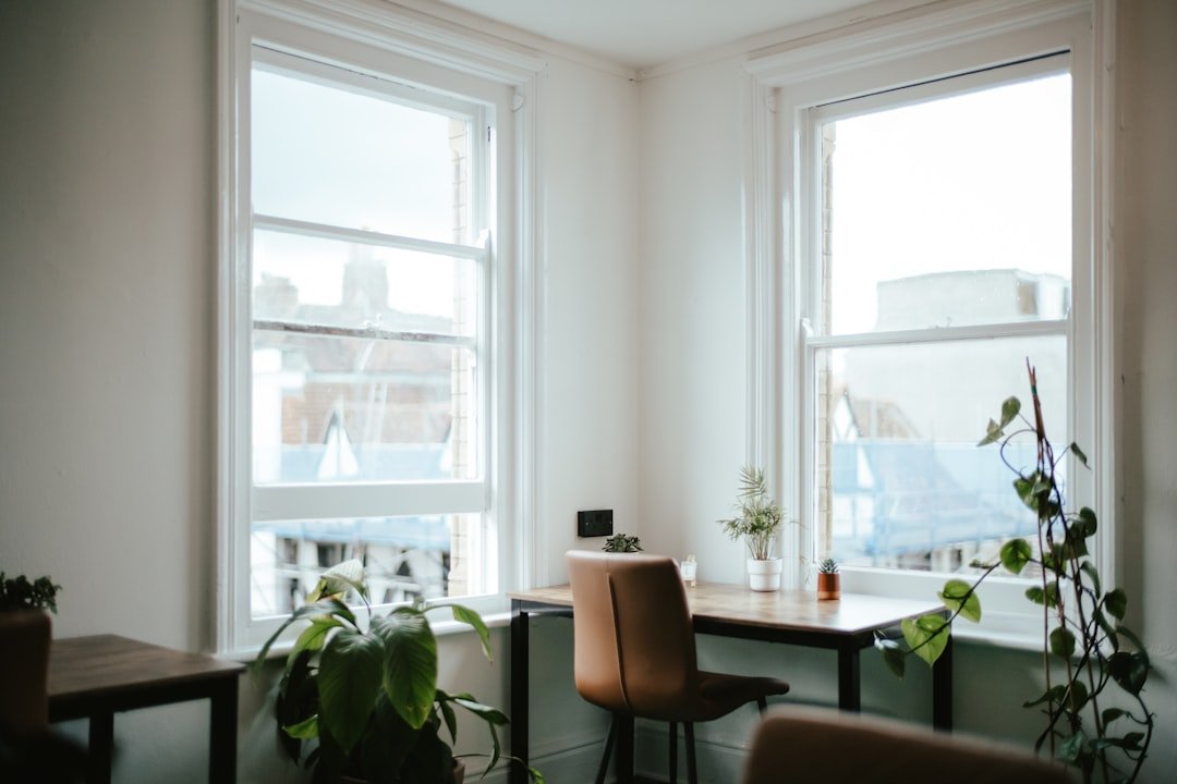 Quiet, bright office corner with a desk, chair, and plants by the window
