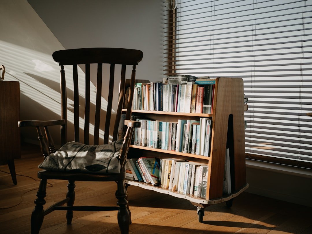 Cozy corner with a wooden chair and a bookshelf in warm daylight